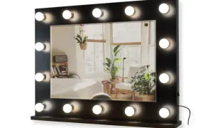 Lustro do toaletki z 16 żarówkami LED, idealne do makijażu. Odbija przytulne wnętrze z roślinami i łóżkiem.